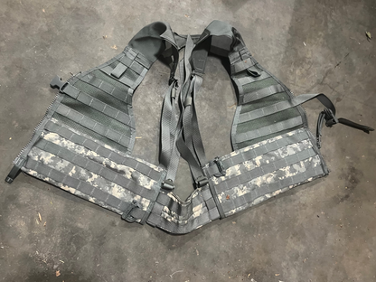 US Military load bearing vest displayed on mannequin, tan in color with multiple pouches and straps.
