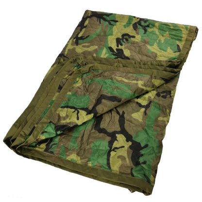 A camouflage patterned US Military WOOBIE/poncho liner laid out flat.