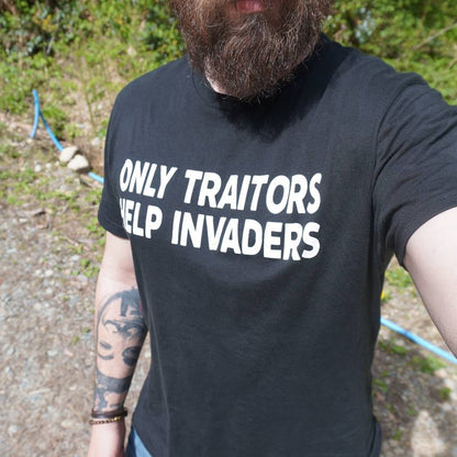 Person wearing a black t-shirt with text outdoors